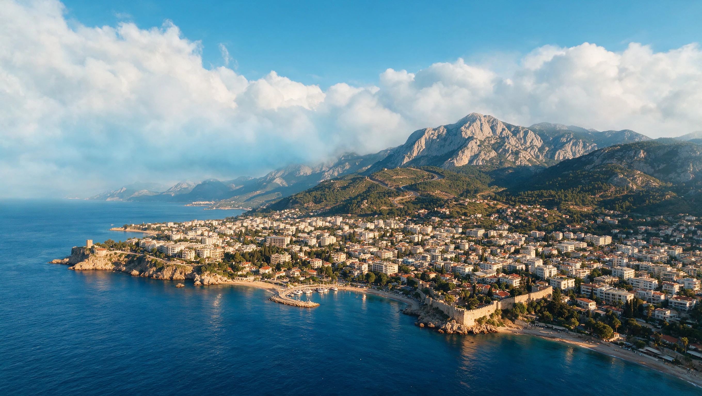 Bulutların altındaki Antalya kıyısı ve Torosların havadan görünümü